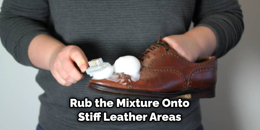 Rubbing the mixture onto stiff leather areas