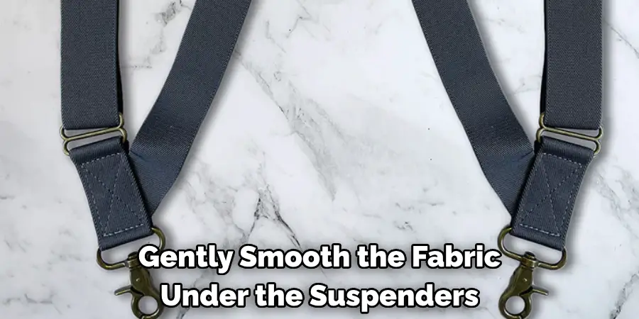 Gently Smooth the Fabric Under the Suspenders